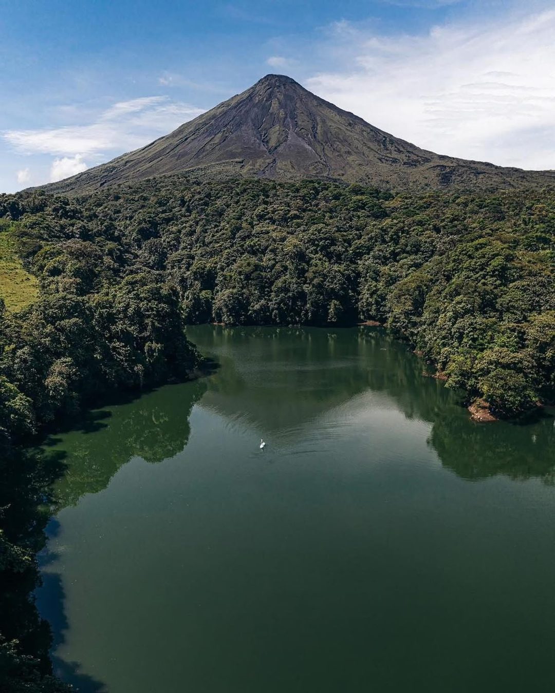 La Laguna Tabacón rodeada de selva, con el Volcán Arenal al fondo